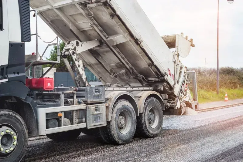 A White Dump Truck on a Road With Its Rear Cargo Bed Raised — Copp & Co Civil Plant Hire in Mount Julian, QLD
