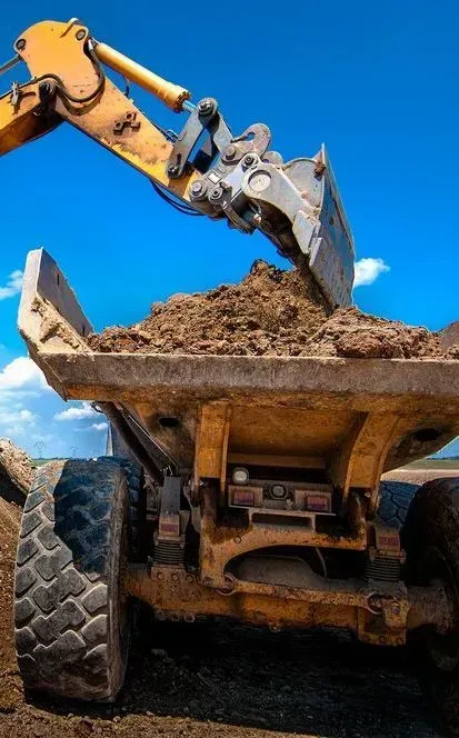 An Excavator Arm Dumps a Scoop of Dirt — Copp & Co Civil Plant Hire in Bowen, QLD