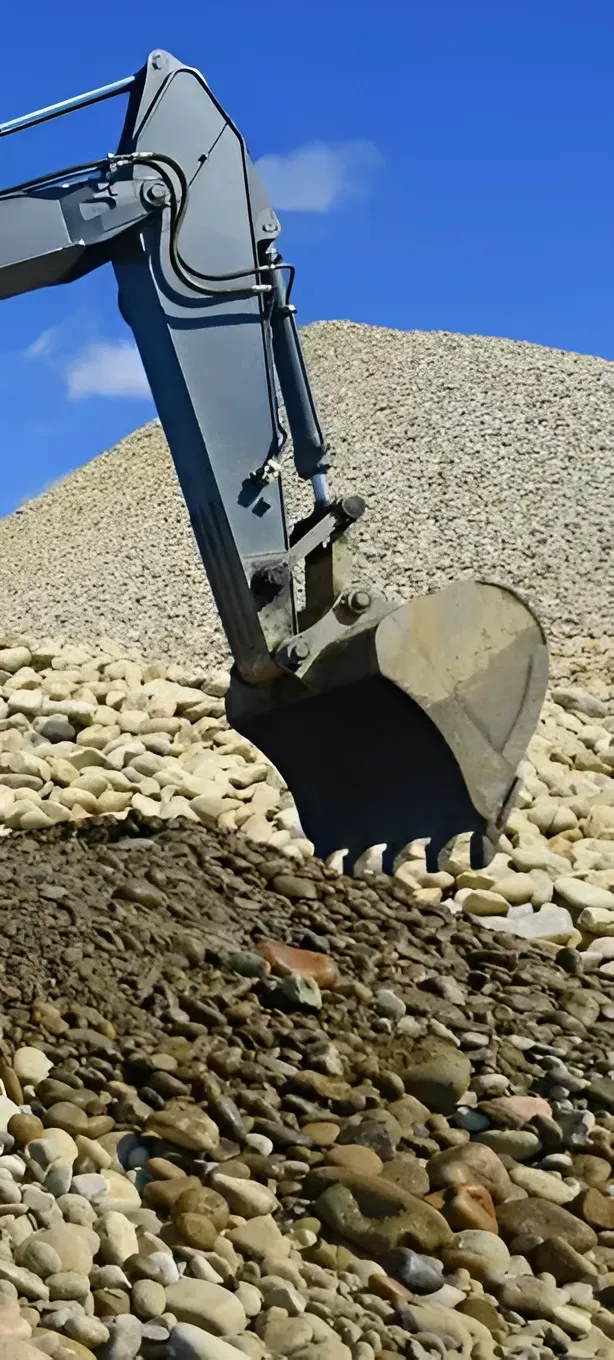 An Excavator Arm and Bucket Positioned Over a Large Pile of Rocks — Copp & Co Civil Plant Hire in Cannonvale, QLD