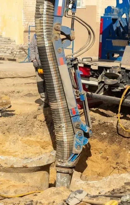 A Large Industrial Suction Hose Attached to a Mechanical Arm Digging — Copp & Co Civil Plant Hire in Bowen, QLD