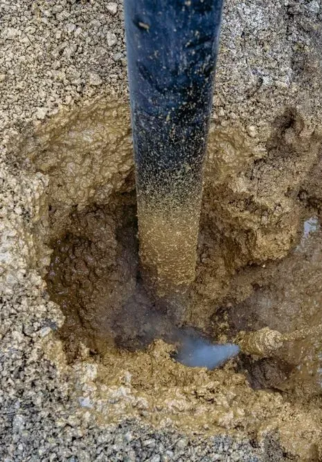 A Black Post Set Into a Hole in the Ground, Surrounded by Loose — Copp & Co Civil Plant Hire in Cannonvale, QLD