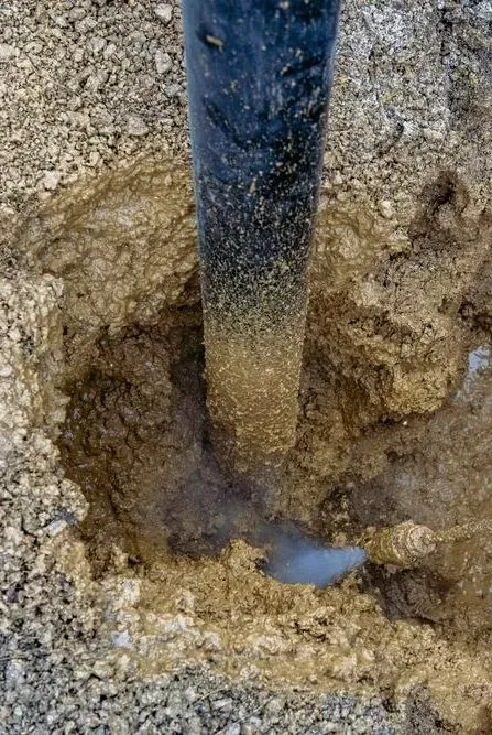 A Close-up View of a Dark Metal Post Set Into a Hole in Sandy — Copp & Co Civil Plant Hire in Mount Julian, QLD