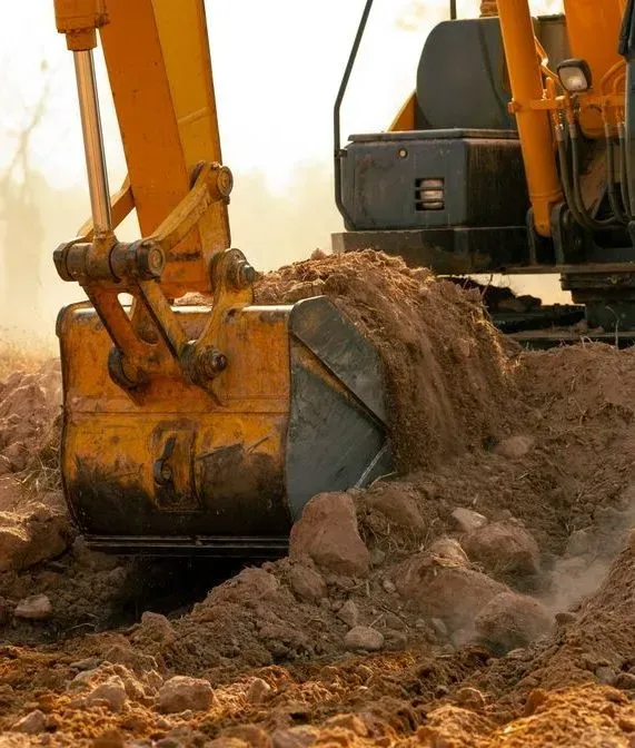 A Yellow Excavator Bucket Digging — Copp & Co Civil Plant Hire in Airlie Beach, QLD