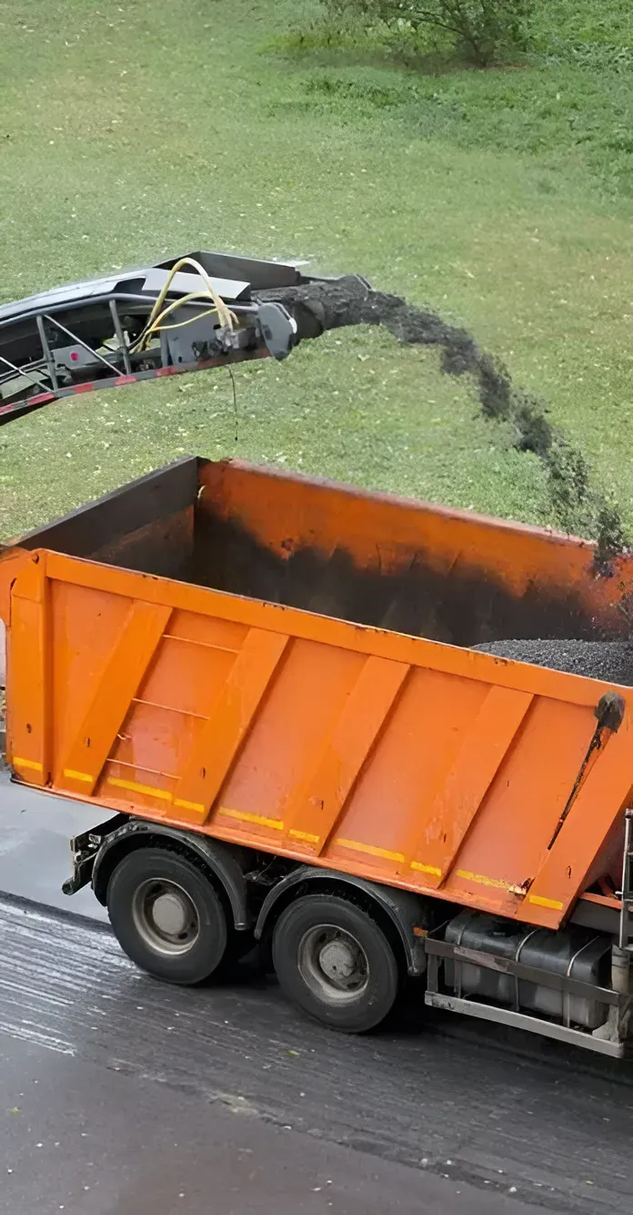 A Road Milling Machine Discharges Ground Asphalt — Copp & Co Civil Plant Hire in Bowen, QLD