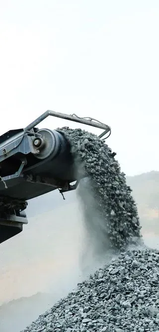 A Conveyor Belt Pouring Grey Crushed Stone Into a Large Pile — Copp & Co Civil Plant Hire in Bowen, QLD