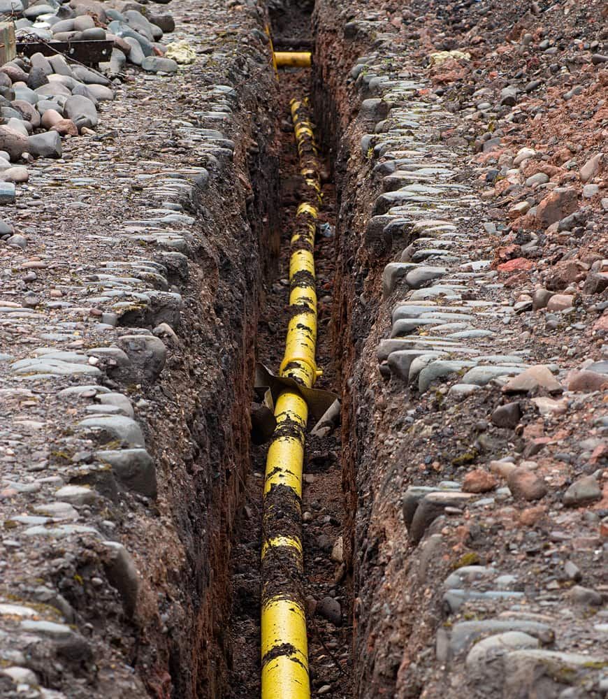 A Bright Yellow Plastic Pipe Runs Along the Center of a Narrow — Copp & Co Civil Plant Hire in Mount Julian, QLD