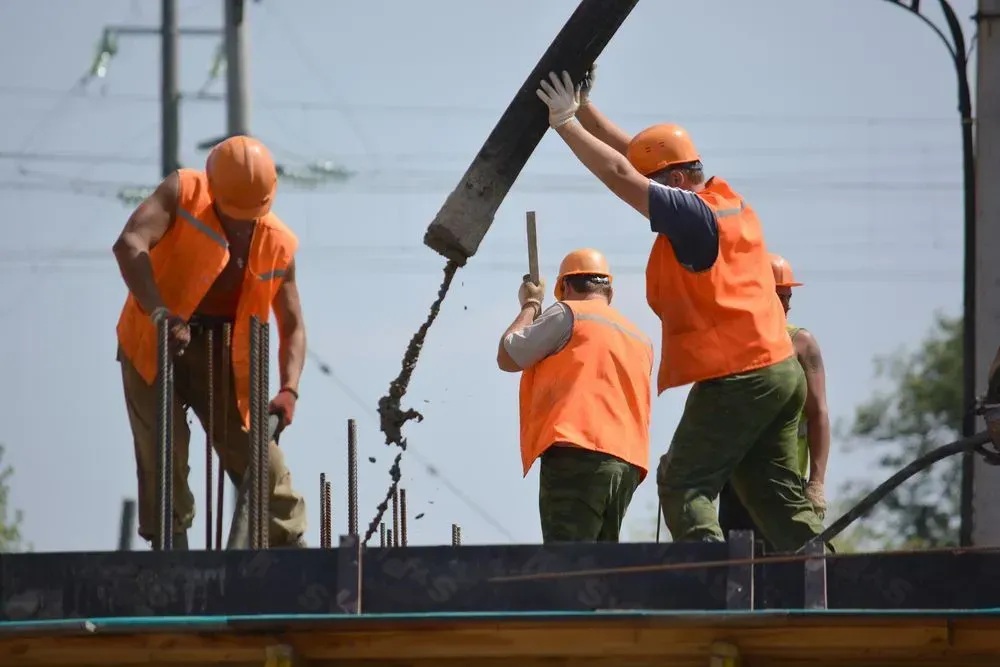 Construction Workers in Orange Safety Vests and Hard Hats Pour Wet — Copp & Co Civil Plant Hire in Proserpine, QLD