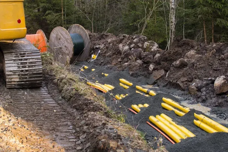 A Construction Site With Yellow Pipes Being Laid in a Trench — Copp & Co Civil Plant Hire in Cannonvale, QLD