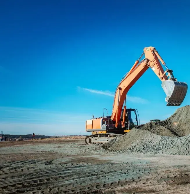 An Orange Excavator Sits on a Dirt Lot With Its Bucket Raised Above a Pile — Copp & Co Civil Plant Hire in Mount Julian, QLD
