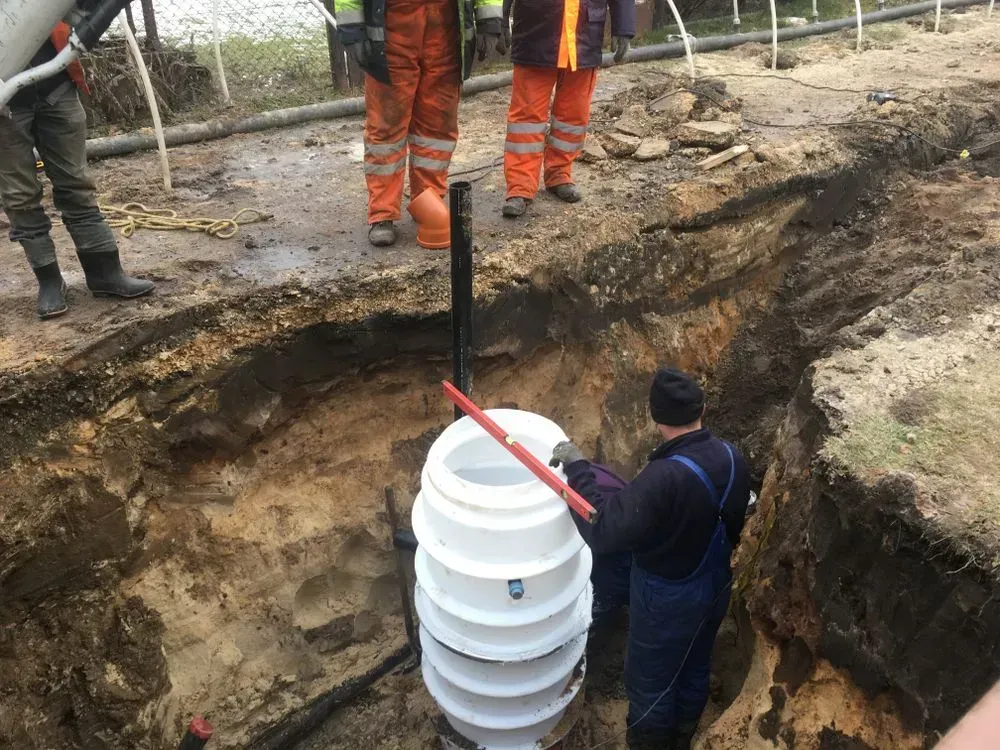 Workers in High-visibility Gear Install a White Plastic Drainage — Copp & Co Civil Plant Hire in Bowen, QLD