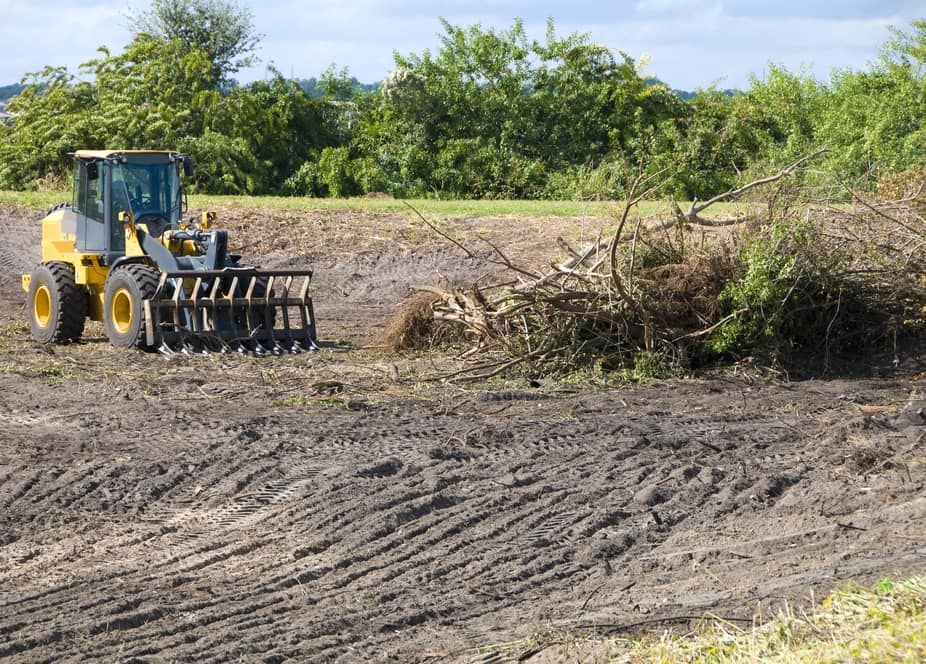 A Yellow Front Loader With a Grapple Attachment Clears — Copp & Co Civil Plant Hire in Mount Julian, QLD