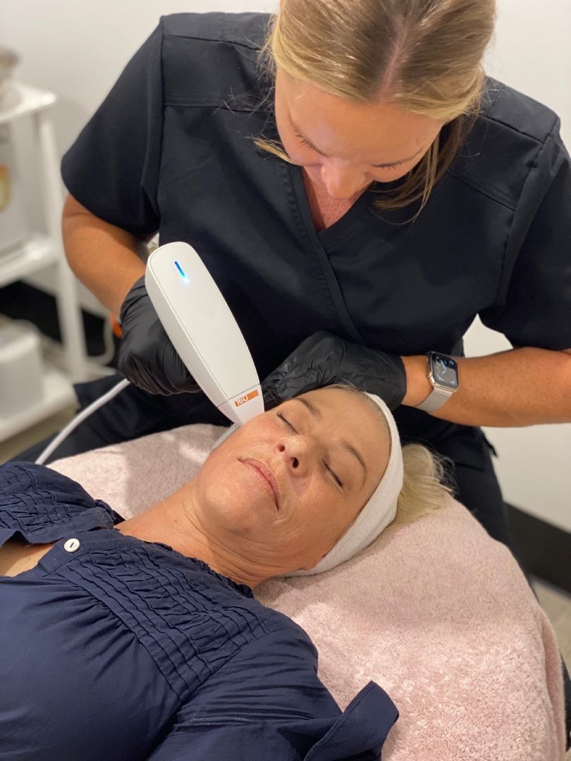 A woman is getting a laser treatment on her face.