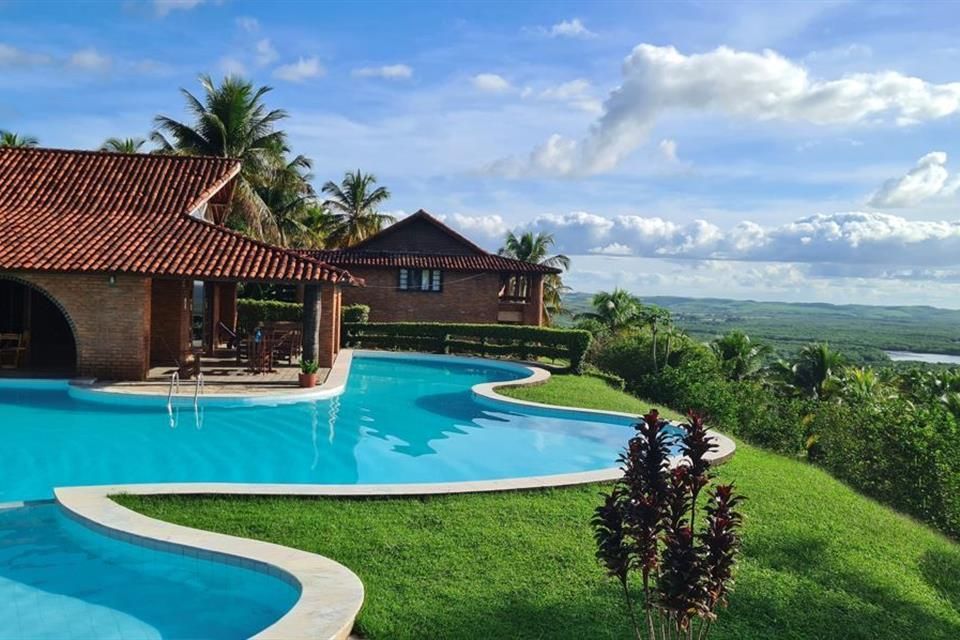 Uma grande piscina com uma casa ao fundo
