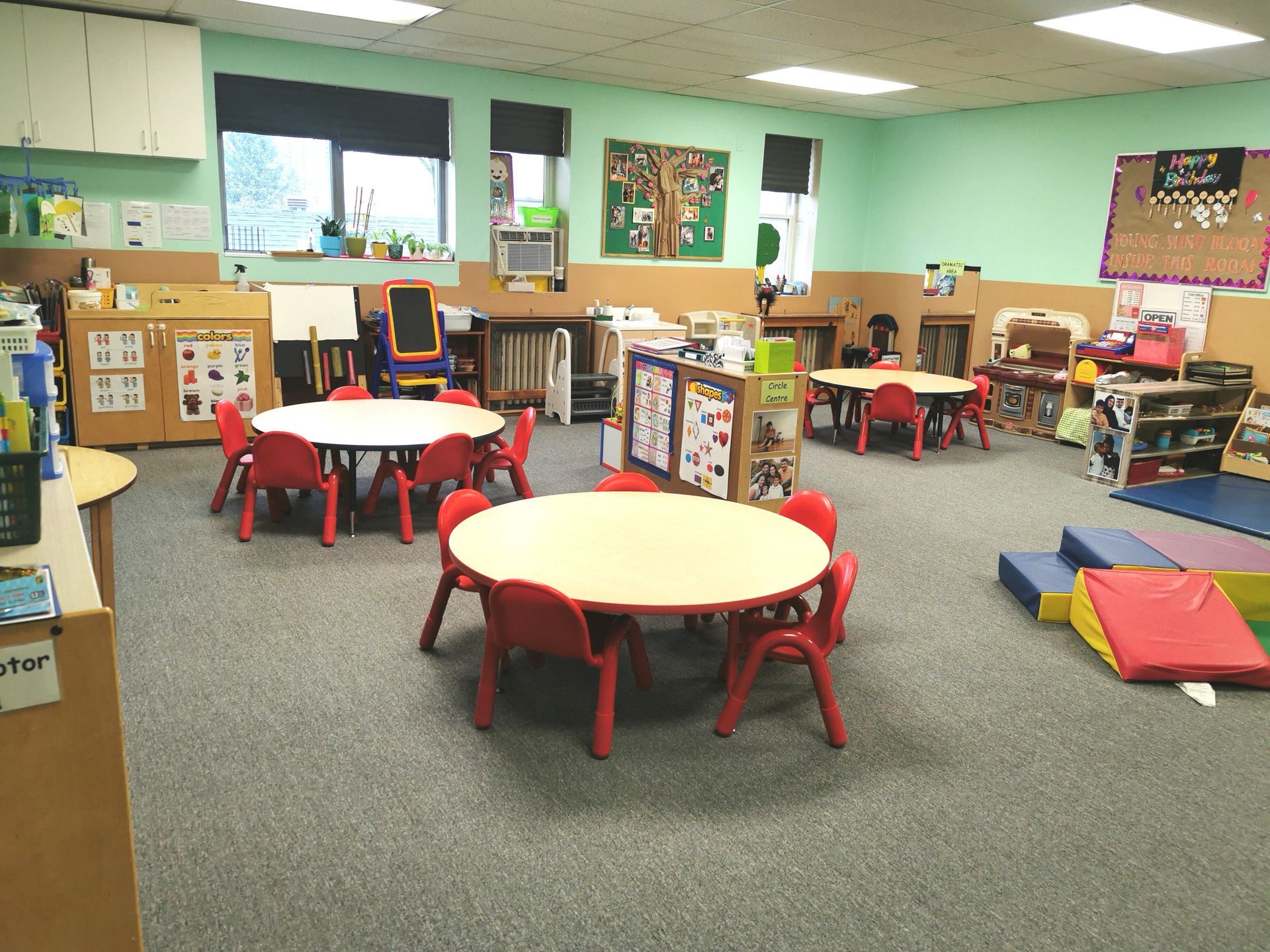inside of preschool daycare filled with round tables and chairs