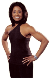 Diane in a black tank top is standing with her hands on her hips.