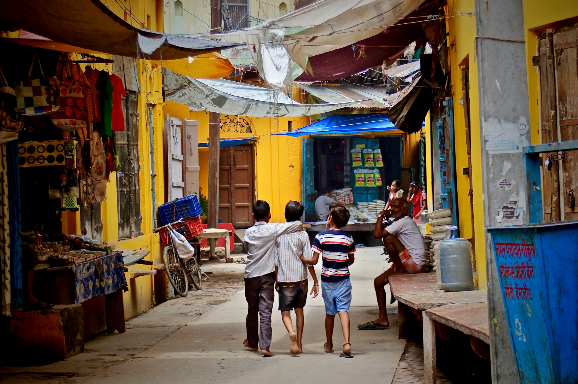 A group of children are walking down a narrow street.
