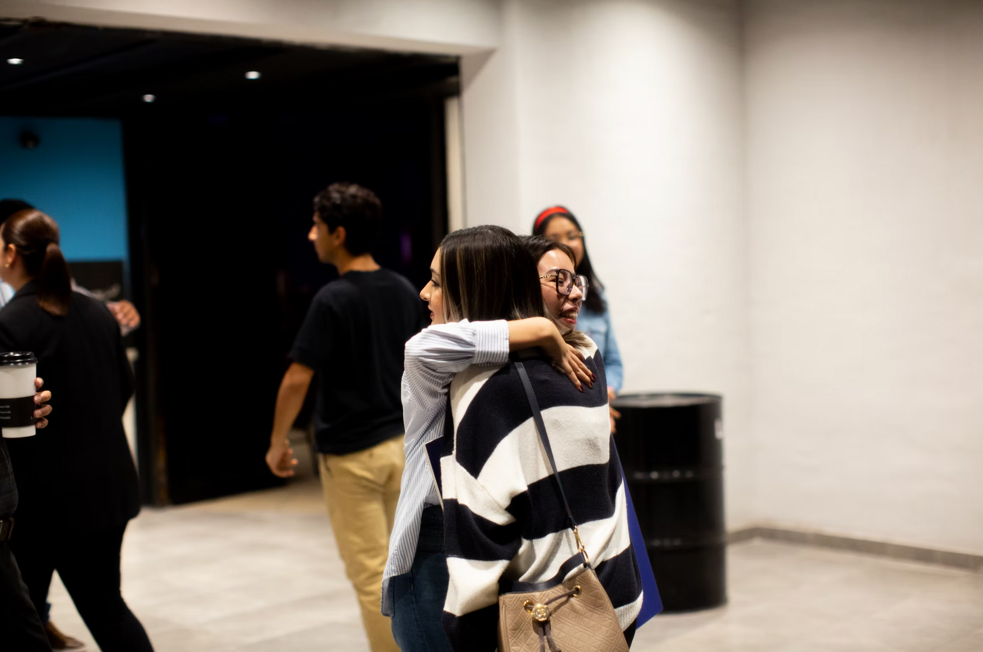 A group of people are hugging each other in a room.