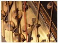 Een close-up van de binnenkant van een piano met een rode snaar.