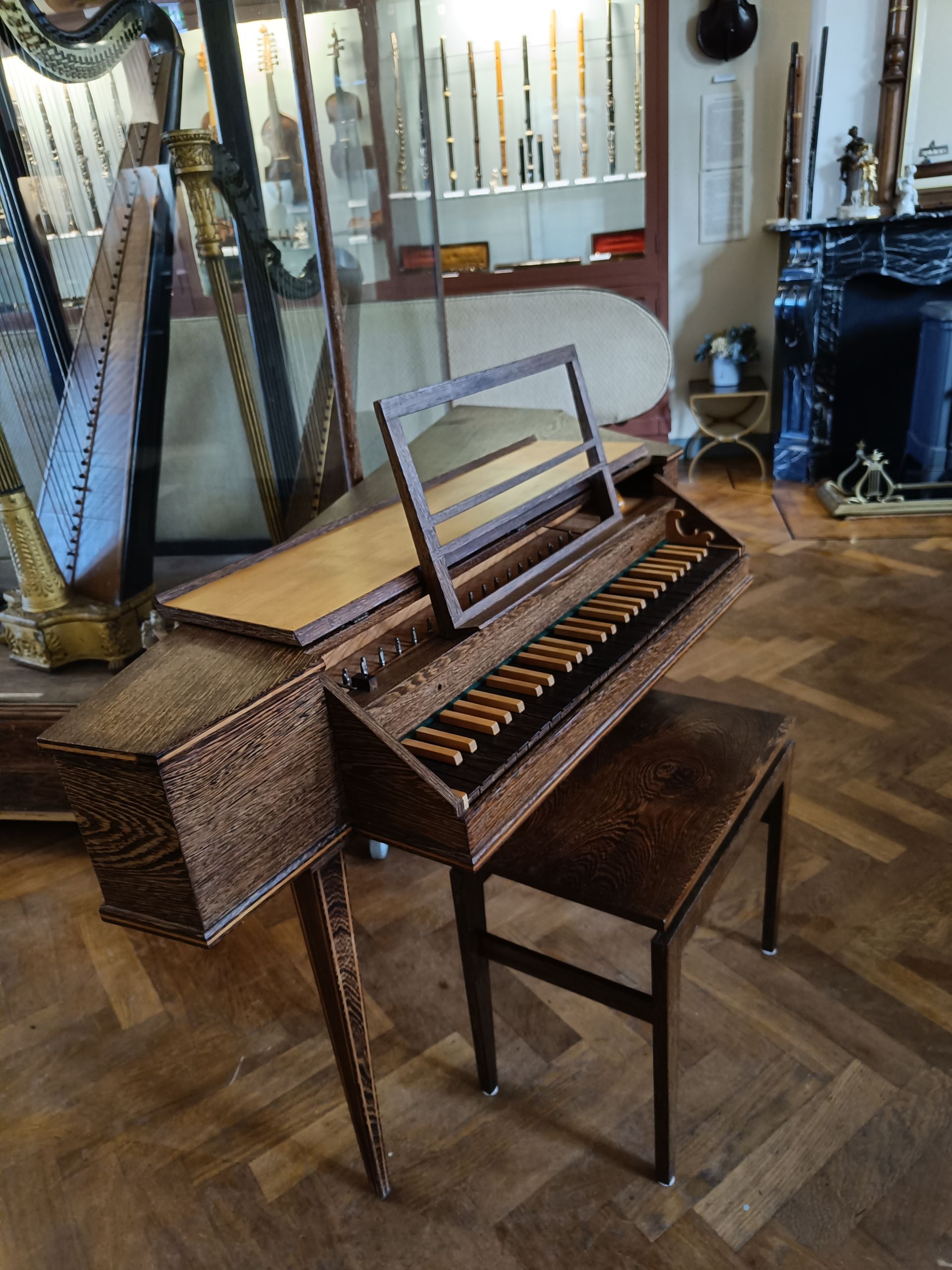 Een piano staat op een houten vloer naast een stoel.