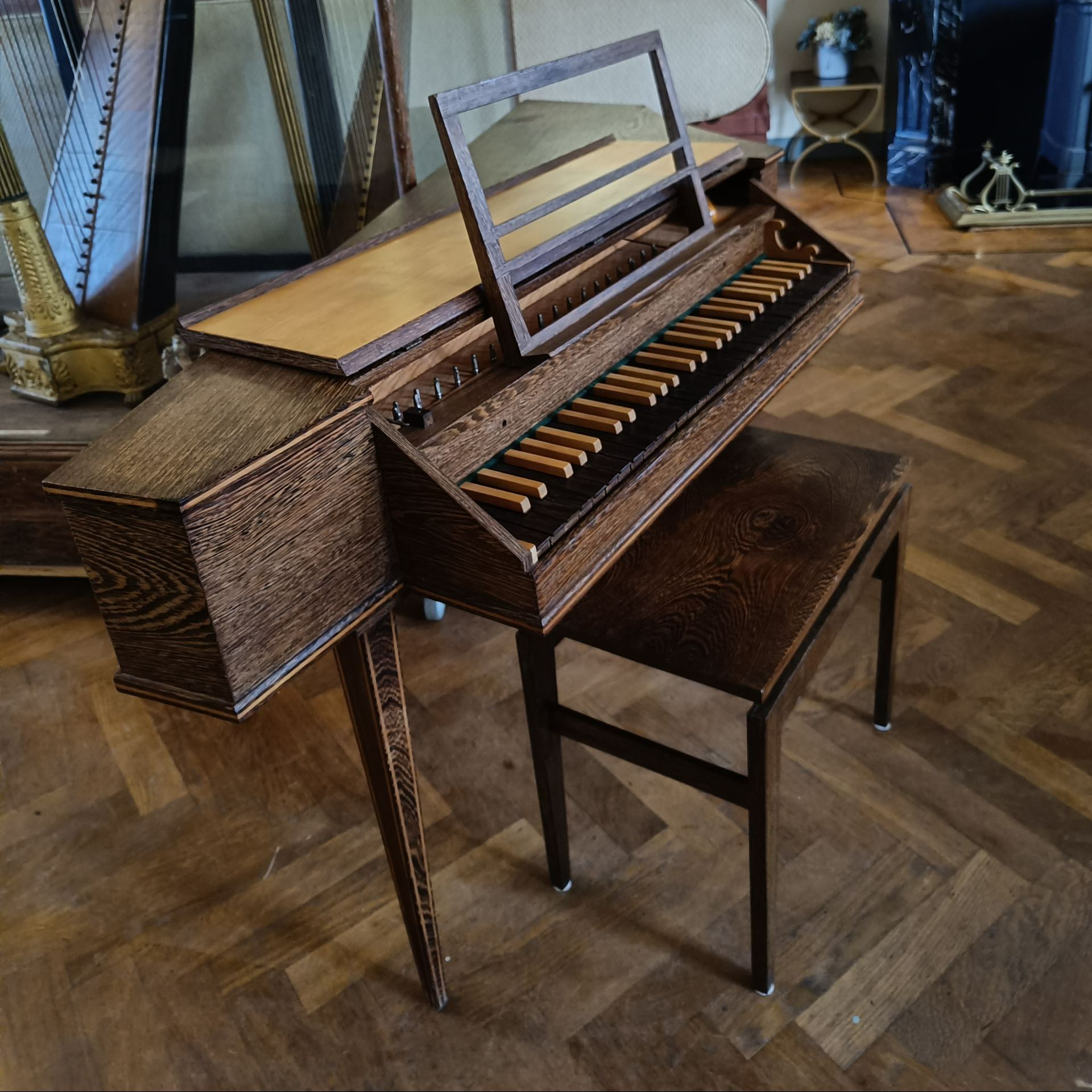 Een piano staat op een houten vloer naast een kruk