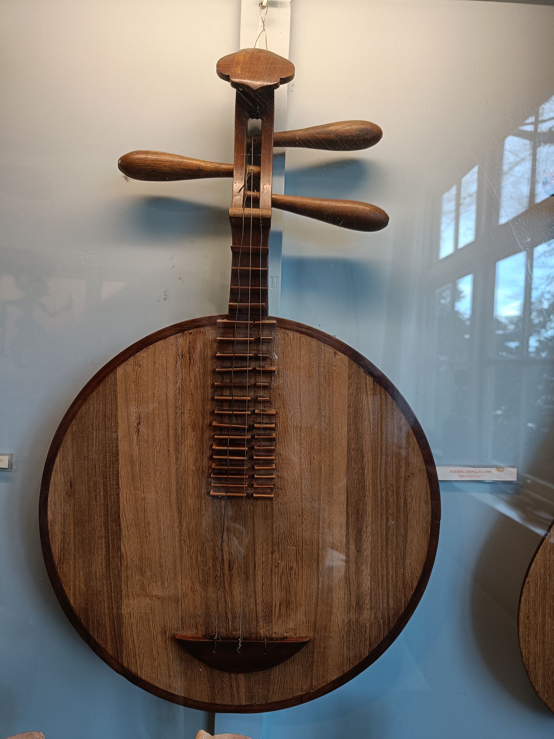 Aan de muur hangt een houten gitaar