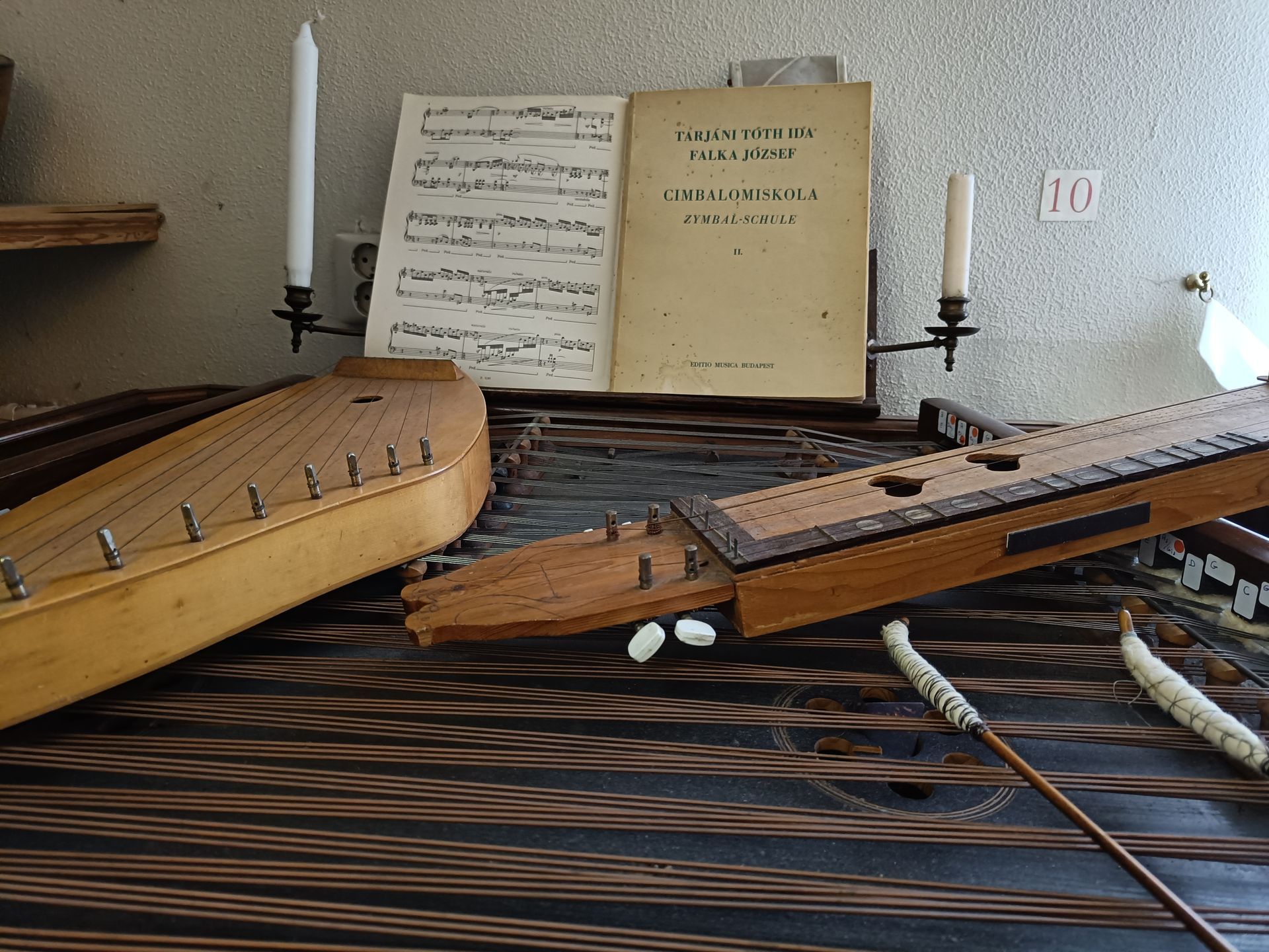Een muziekinstrument zit op een tafel naast een boek en kaarsen
