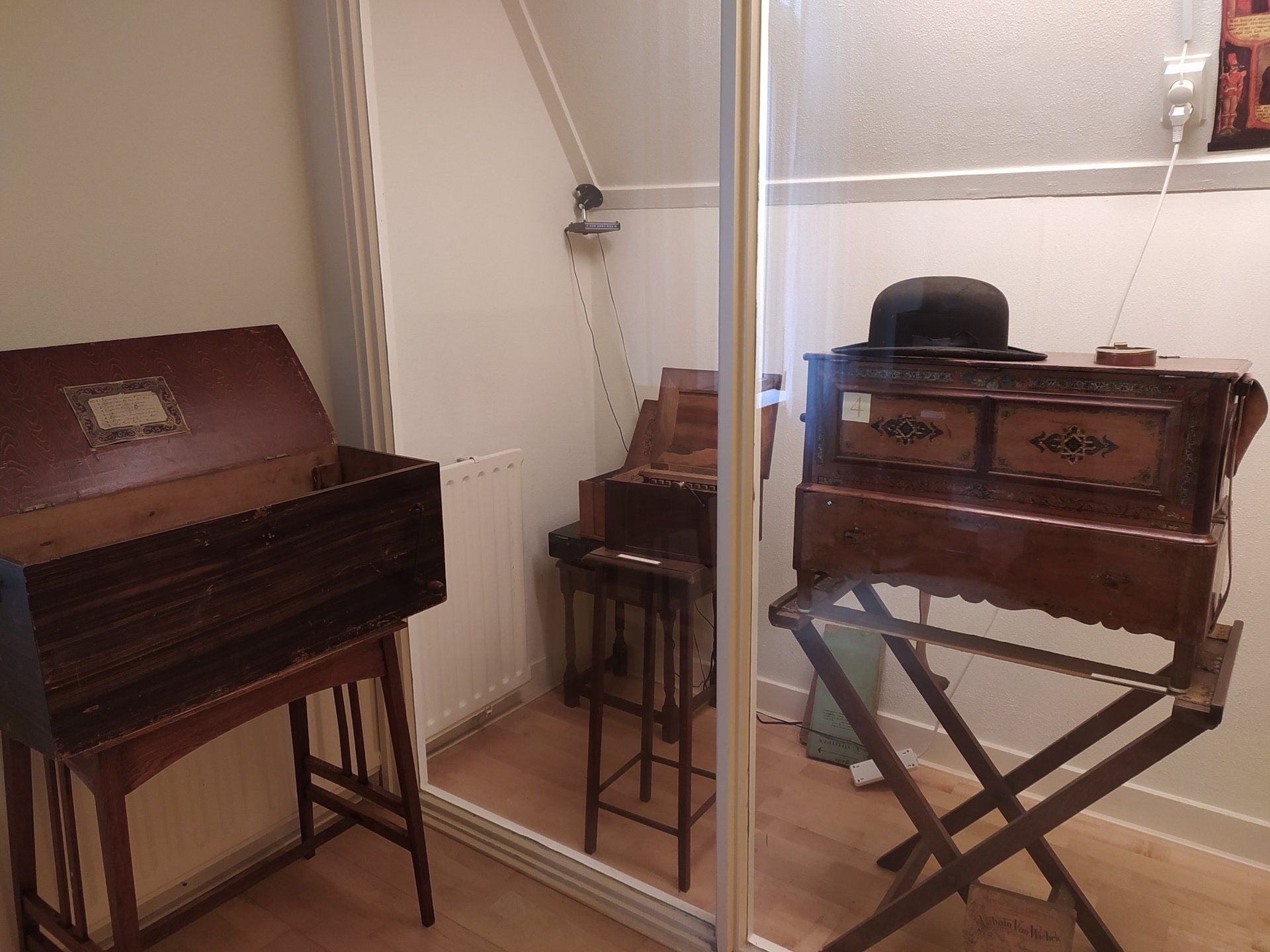 Een kamer met twee houten bureaus en een glazen deur
