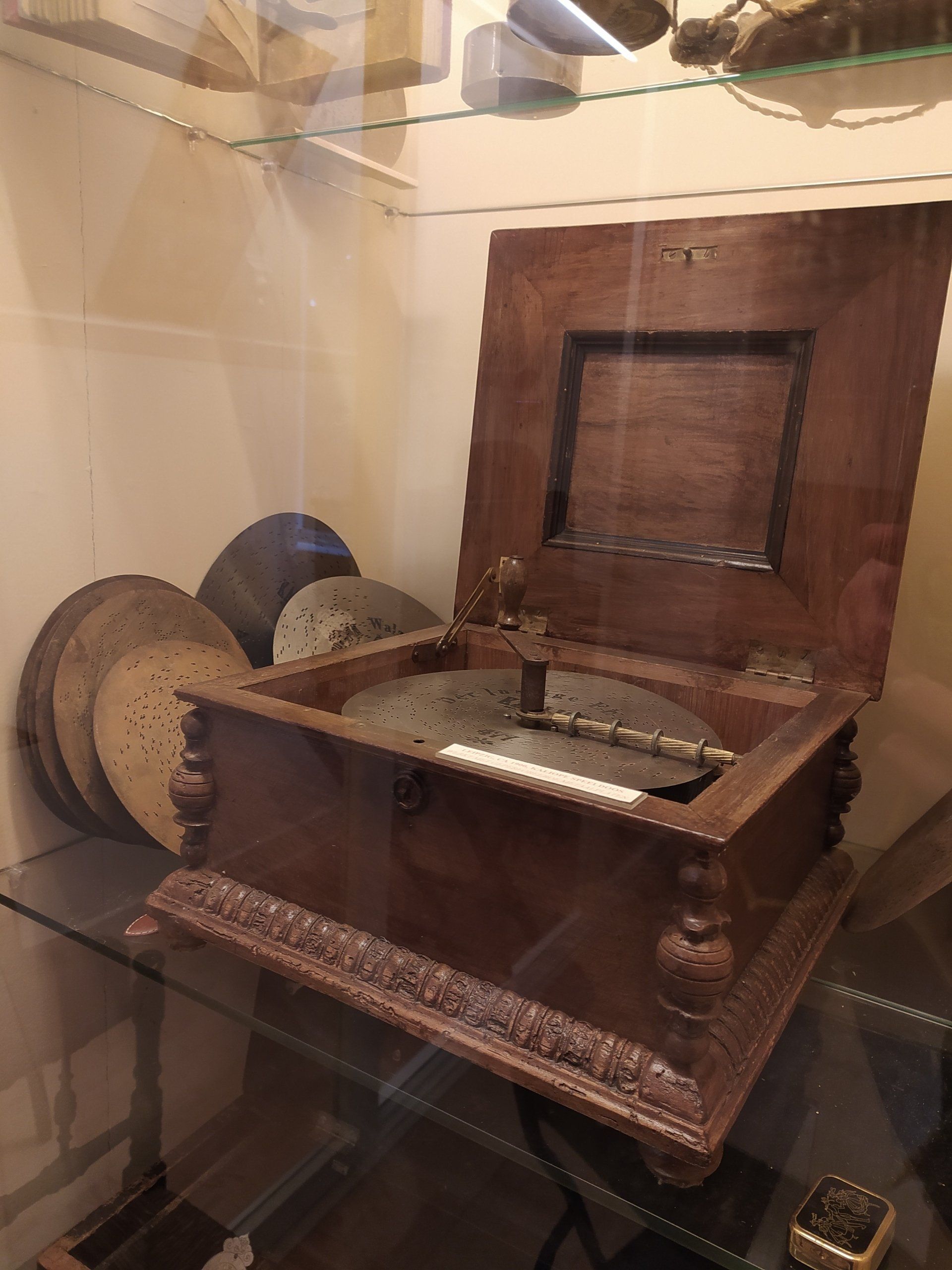Op een glazen tafel staat een oude houten muziekdoos.