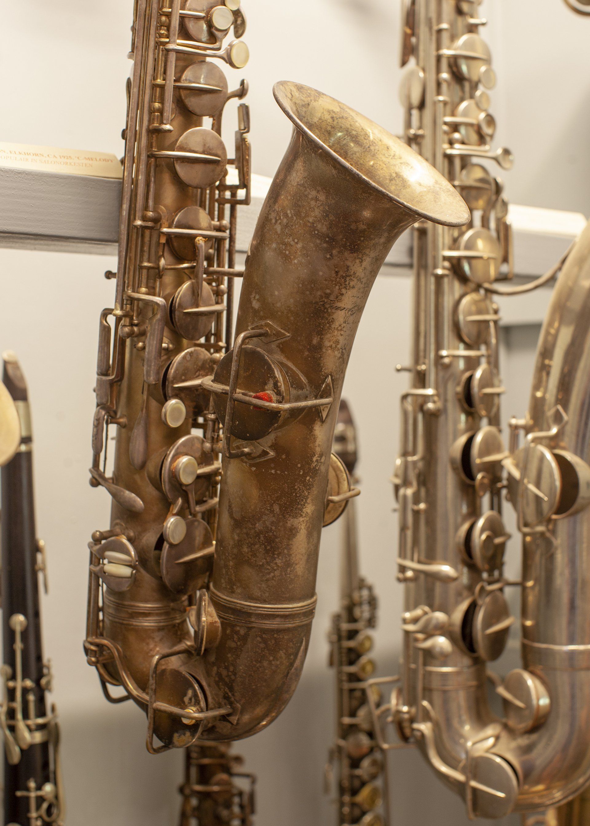 Een close-up van een saxofoon die aan een muur hangt