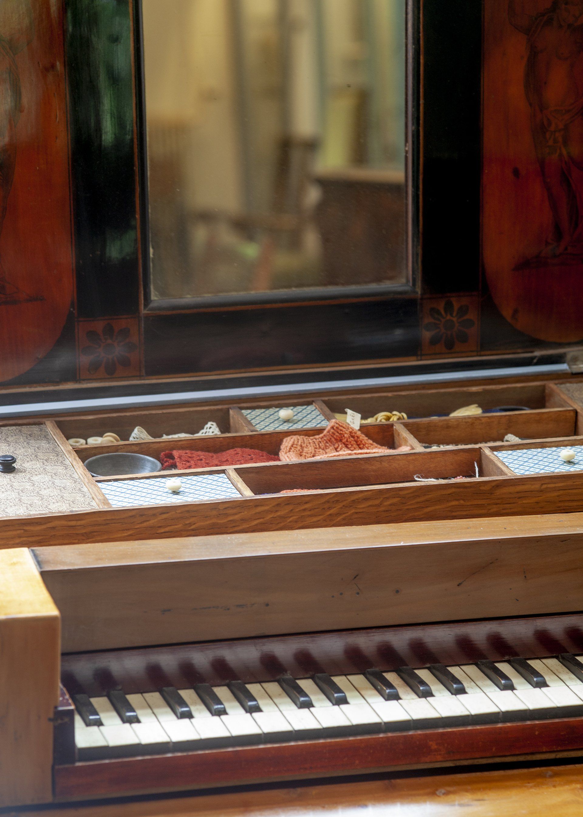 Een piano staat op een houten tafel voor een spiegel