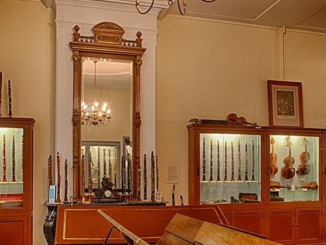 Een kamer met veel muziekinstrumenten tentoongesteld