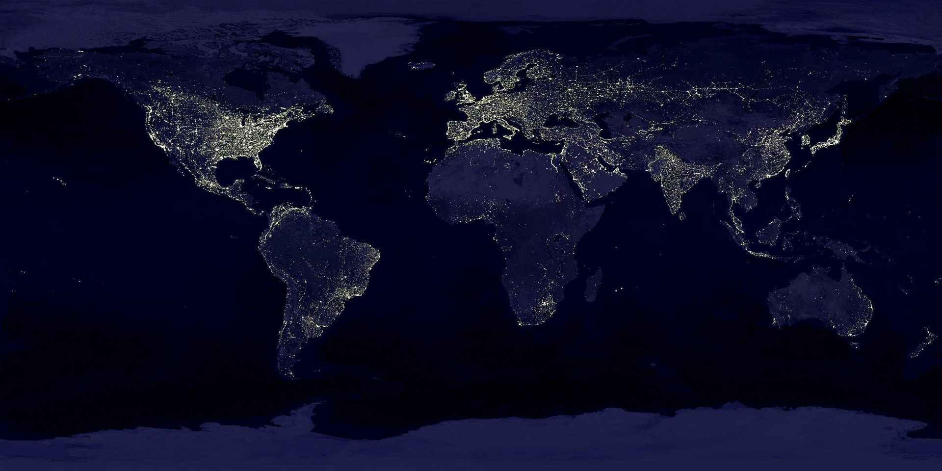 Wereldkaart 's nachts, met de gloeiende stadslichten. Noord-Amerika en Europa zijn bijzonder helder verlicht.