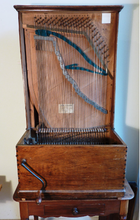Op een houten tafel zit een houten harp.