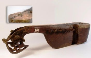 Een houten voorwerp met een uitgesneden handvat zit op een wit oppervlak.