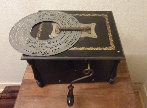 Een zwarte doos met daarop een metalen schijf