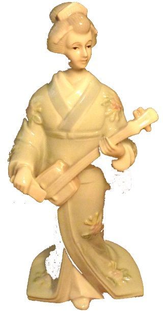 Een beeld van een vrouw in een kimono die een gitaar vasthoudt.