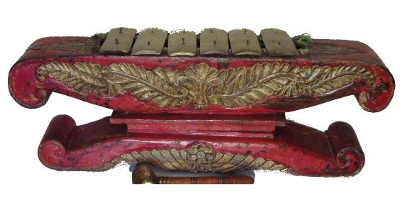 Een houten muziekinstrument met een rode voet en bladgoud erop.