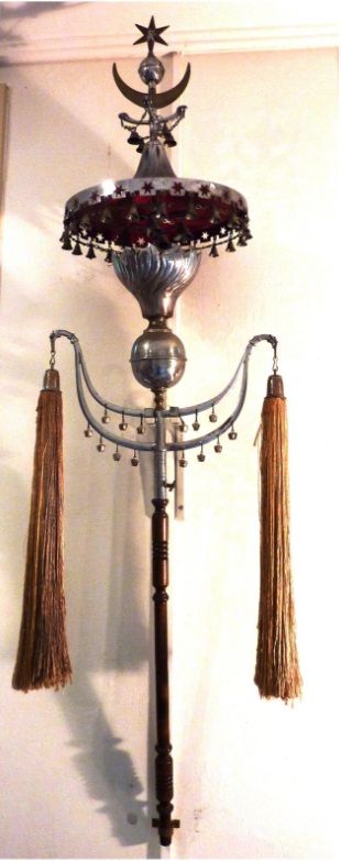 Aan de muur hangt een lamp met kwastjes.