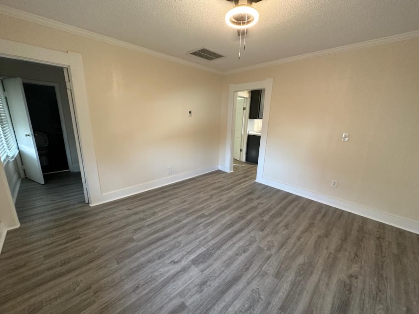 An empty room with hardwood floors and white walls.