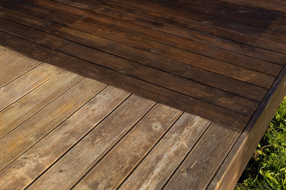 A close up of a wooden deck before and after being cleaned.