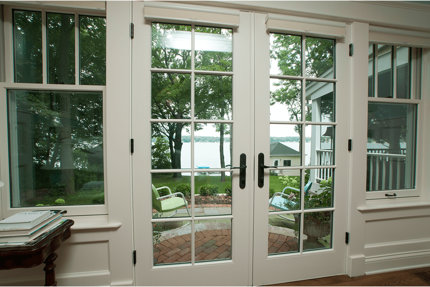 White French doors and windows opening to a green backyard patio