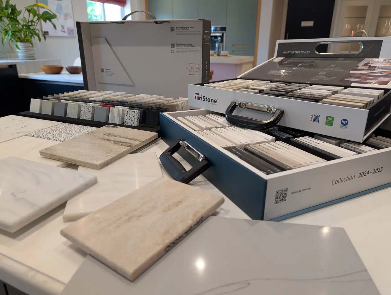 Sample tiles and display boxes arranged on a table in a showroom.