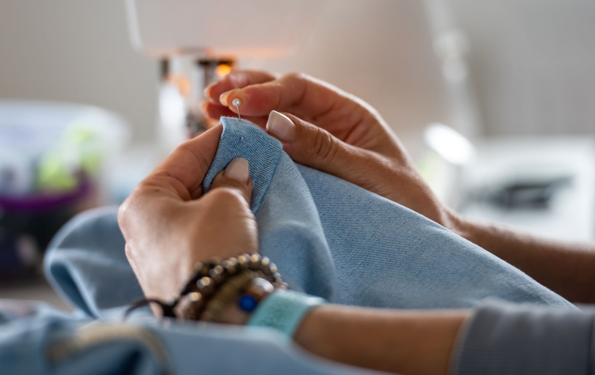 Hands holding a blue knitted blanket with a hospital wristband visible