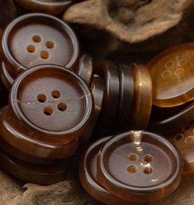 Brown buttons stacked together, close-up view