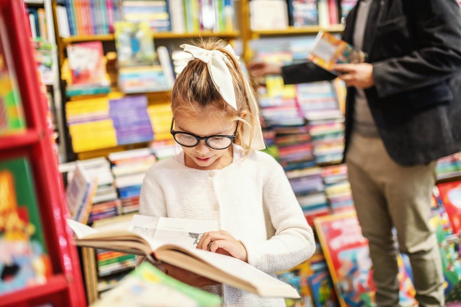 Young Girl Reading Book in Bookstore
