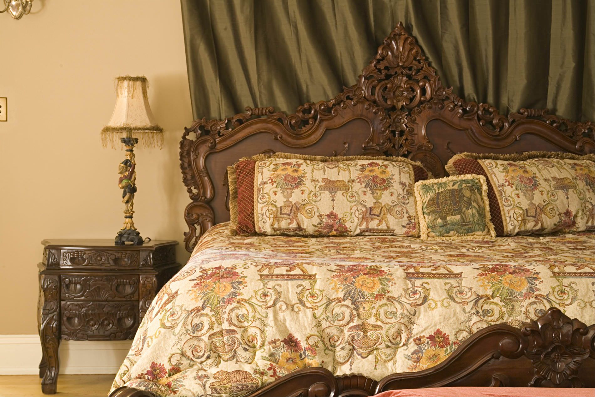 A bedroom with a bed a nightstand and a lamp