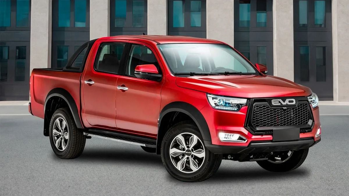 Un pick-up rosso parcheggiato davanti a un edificio moderno.