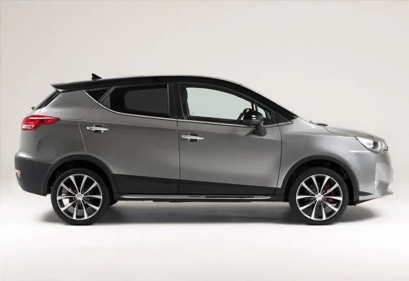 SUV compatto grigio visto di profilo su sfondo bianco in studio.