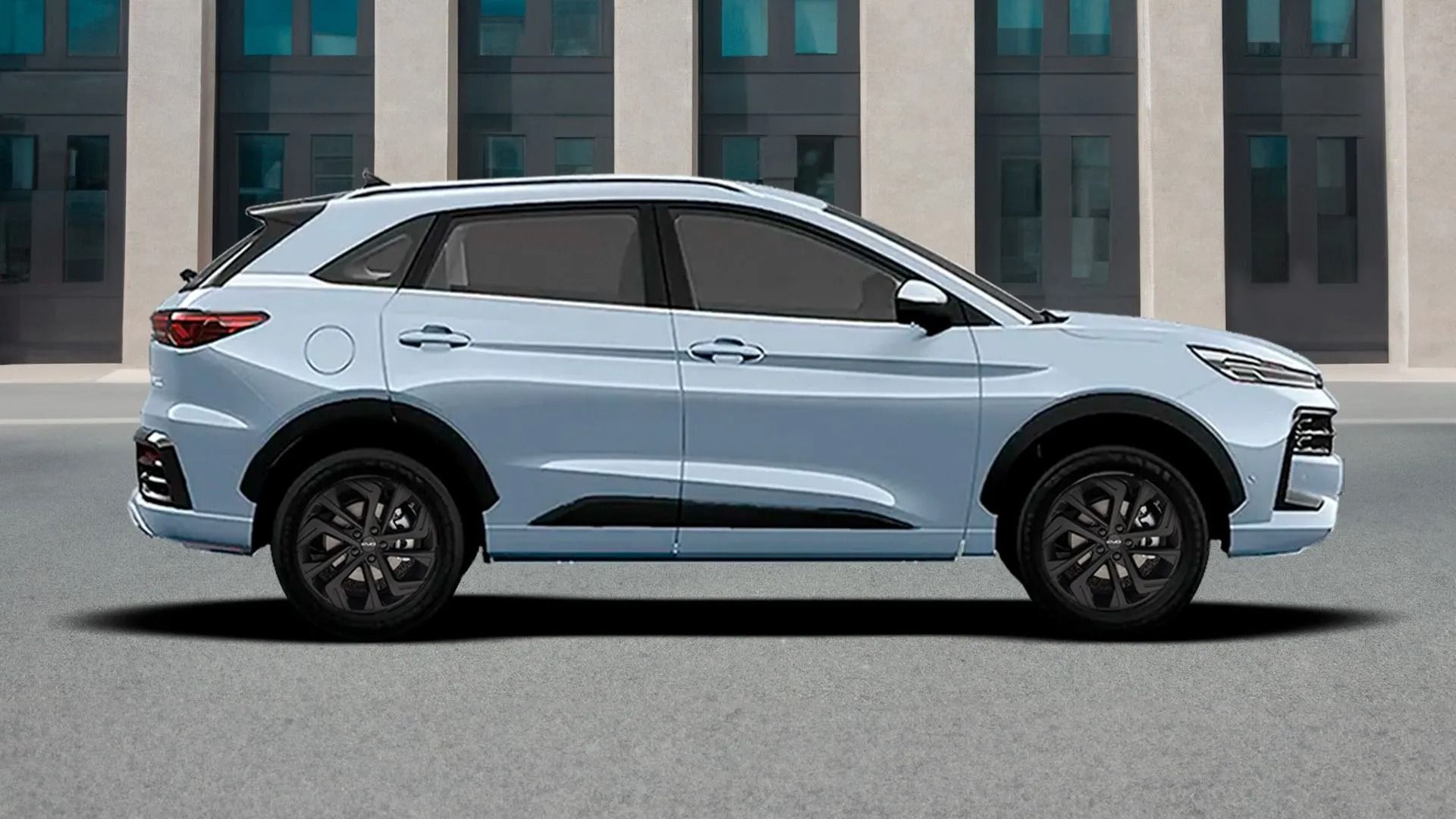 Vista laterale di un SUV azzurro parcheggiato davanti a un edificio.