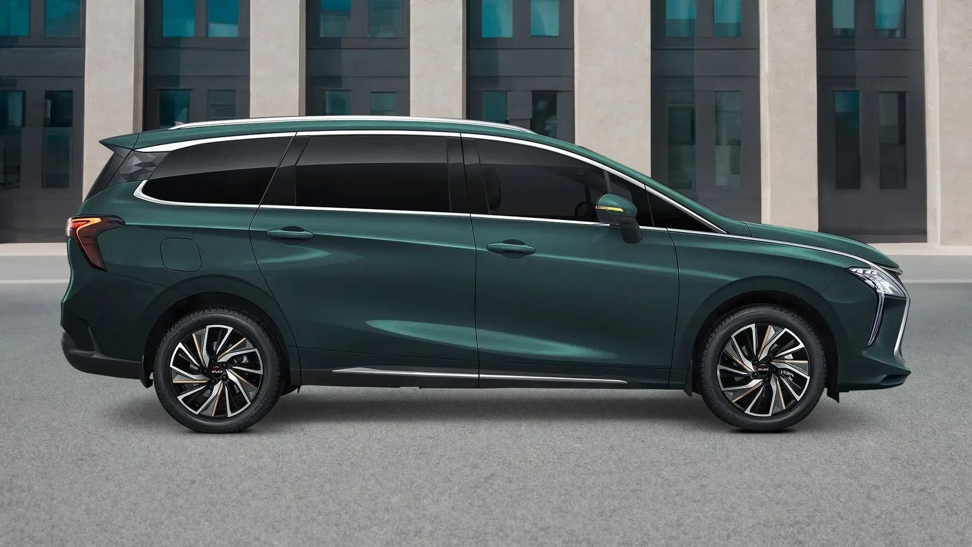 Un SUV verde scuro parcheggiato davanti a un edificio moderno.